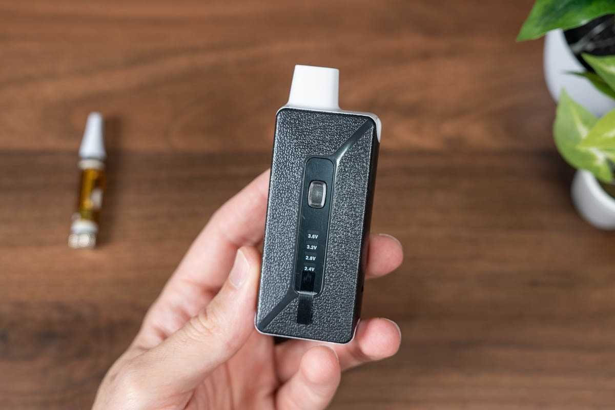 Person shopping for vape products on a laptop with vape devices and e-liquids nearby