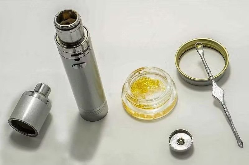 Close-up of a dab pen vaporizer being used safely with a steady hand