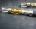 Close-up of a nicotine vape device producing vapor with e-liquid and battery components visible