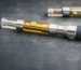 Close-up of a nicotine vape device producing vapor with e-liquid and battery components visible
